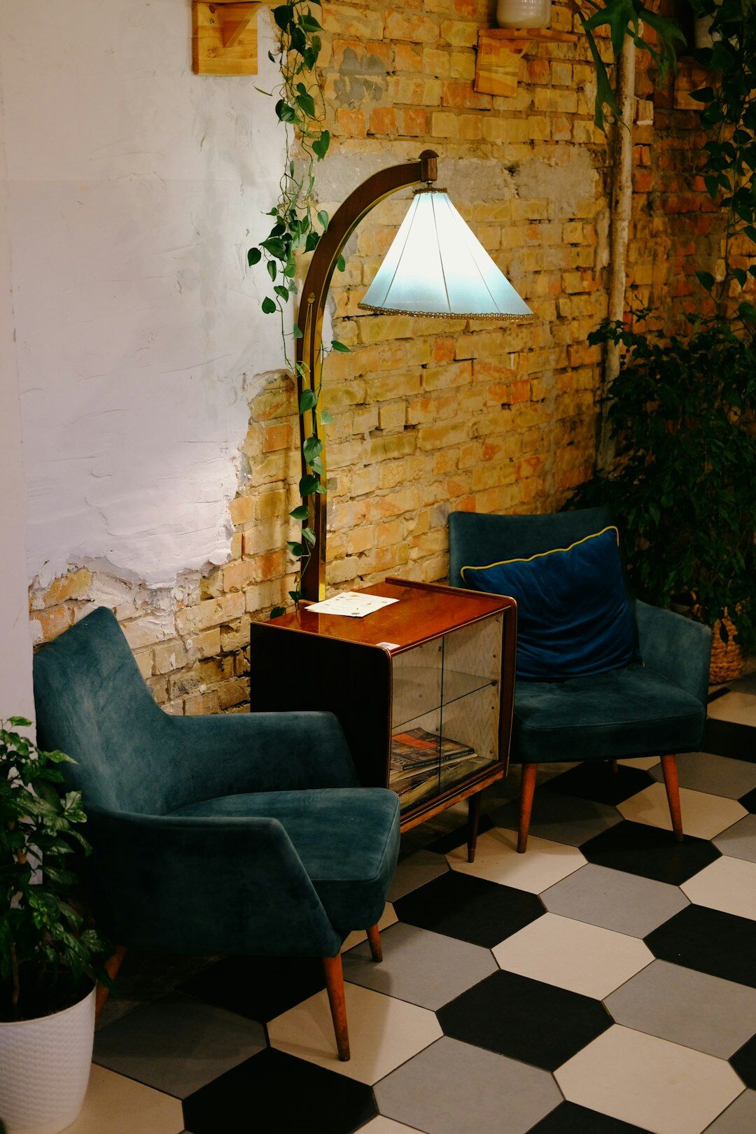 Retro nineteen eighties style lounge with velvet armchairs and brass lamps
