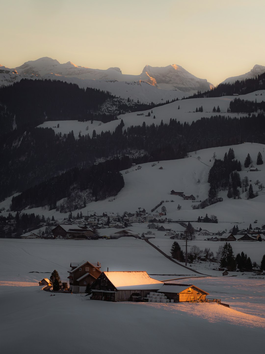 Traditional Swiss wooden chalet exterior in the snowy Alps at dusk